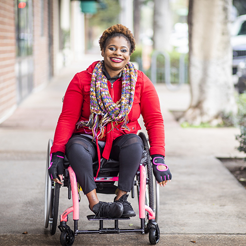 A woman in a wheelchair working.